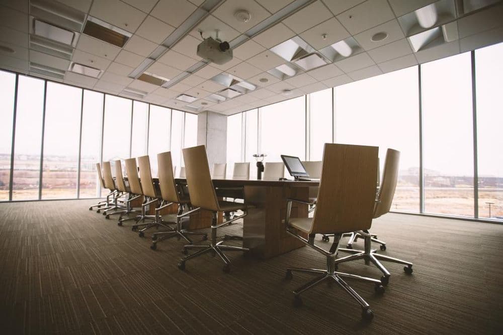 An empty office meeting room with chairs around a long table