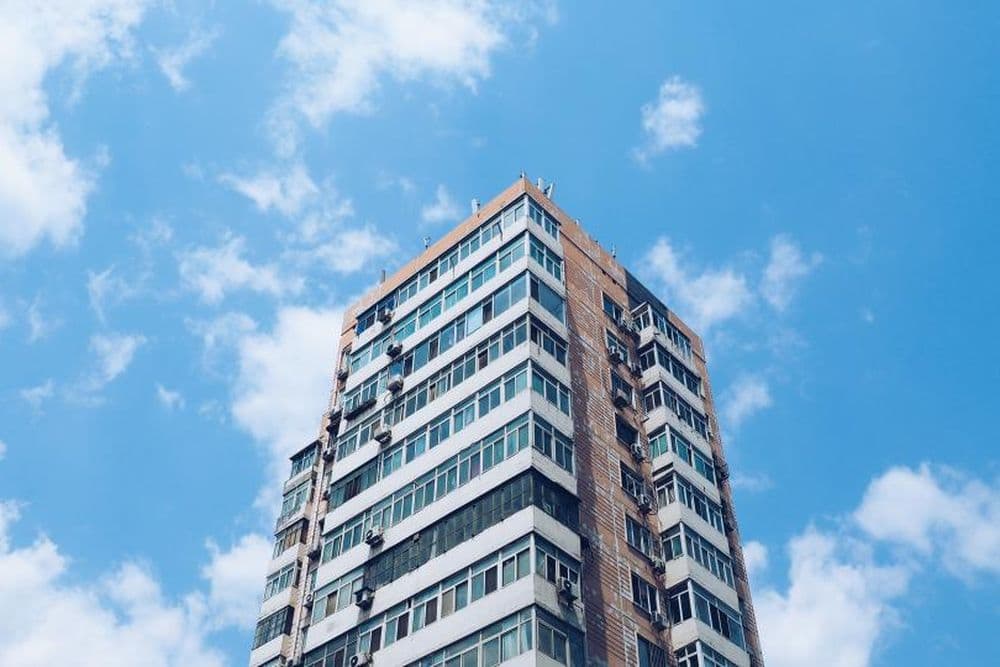 A residential apartment tower against a blue sky