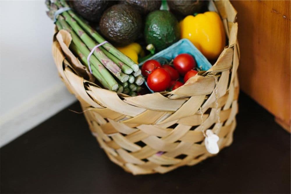 A basket of fresh vegetables and groceries